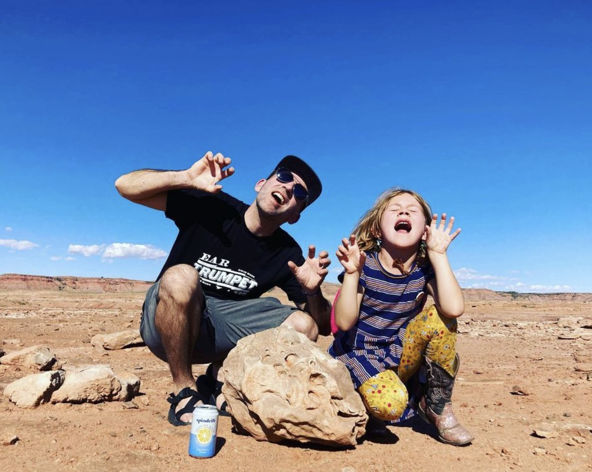 justin farren and daughter pose with silly faces outside in desert